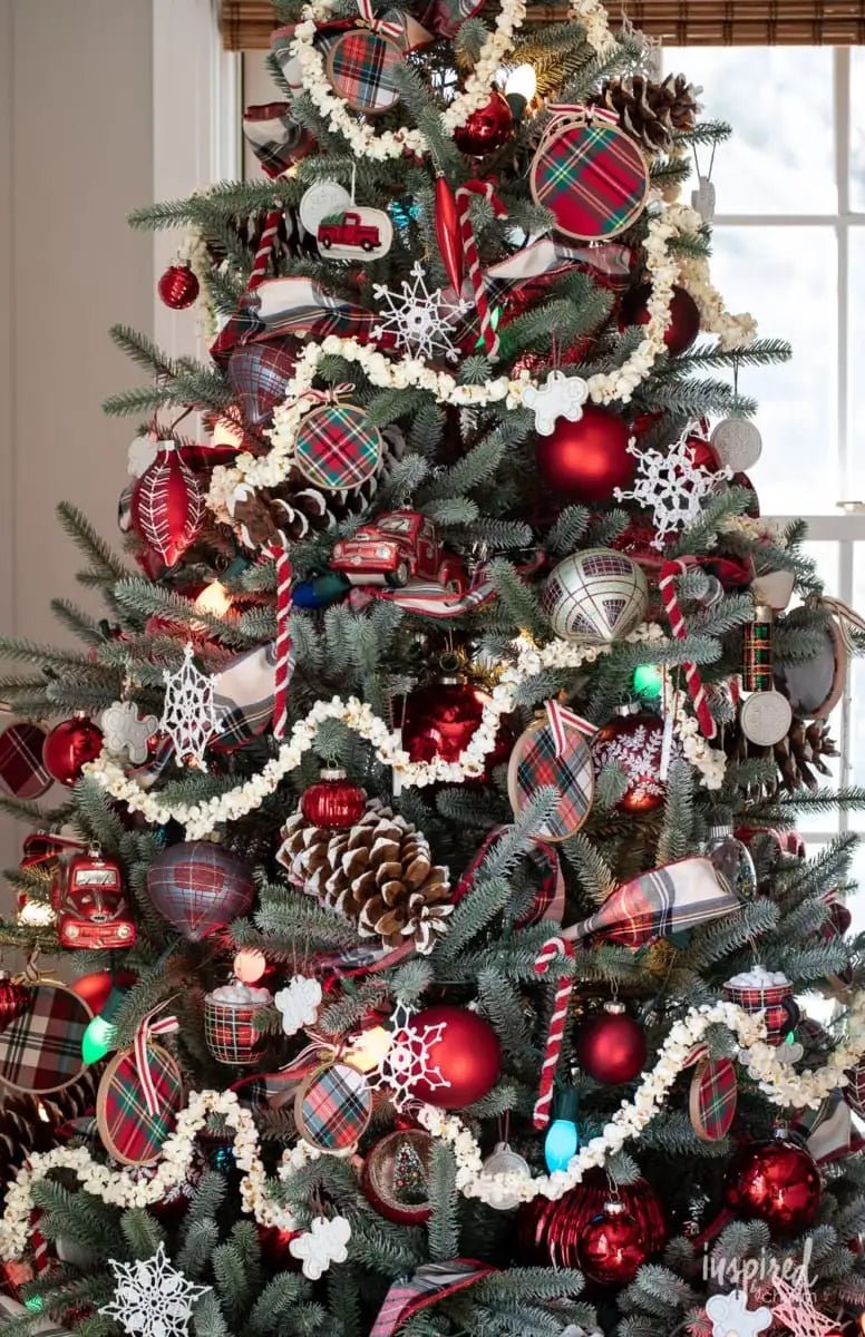 Professionally decorated Christmas tree with red plaid ornaments, snowflakes, and pinecones in Dallas-Fort Worth.