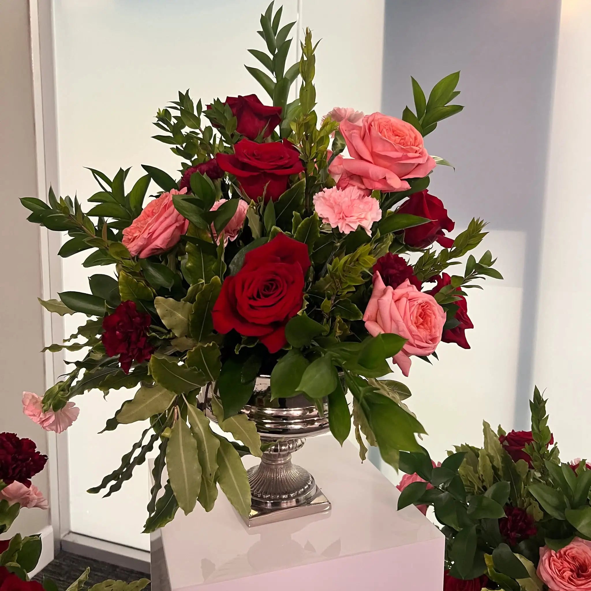 Elegant corporate flower arrangement featuring red and pink roses for client appreciation and business events