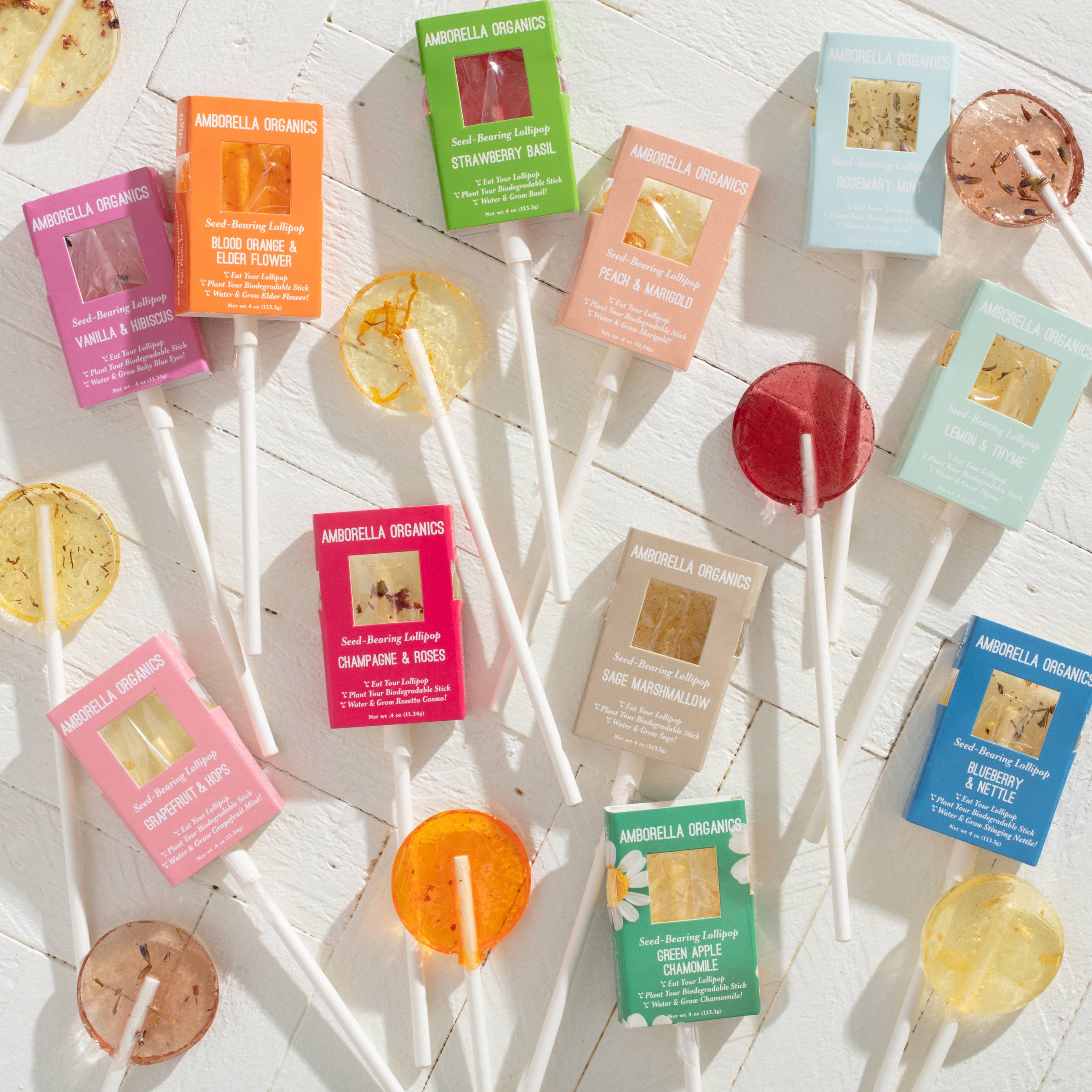 Assorted lollipops with colorful packaging on a light wooden surface