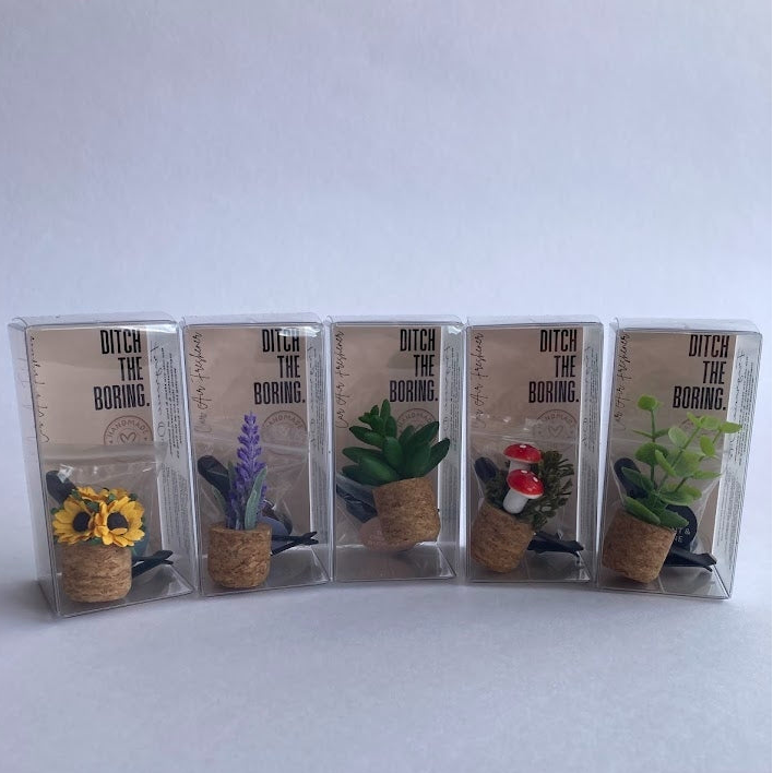 variety of five packaged car vent clip air fresheners with cork bottoms and plant toppers. 