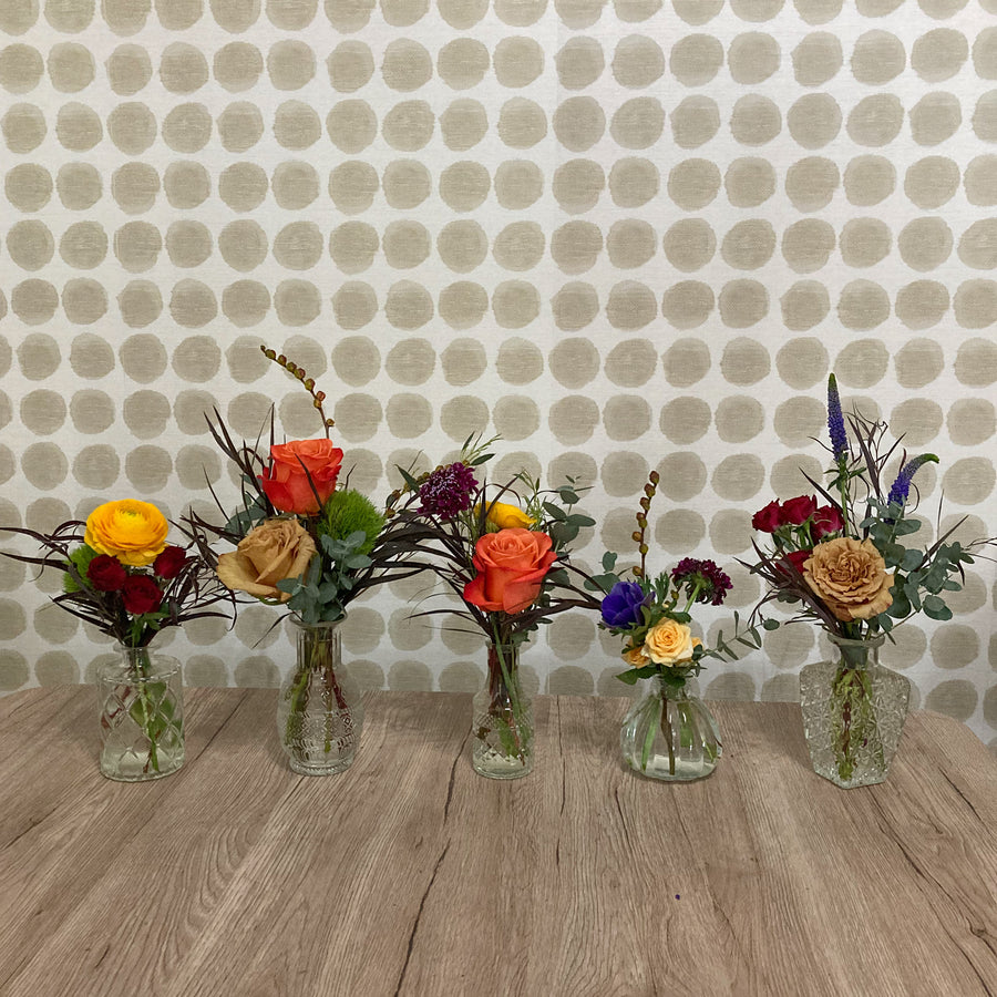 Styled bud vases with fall flowers arranged for a Thanksgiving tablescape