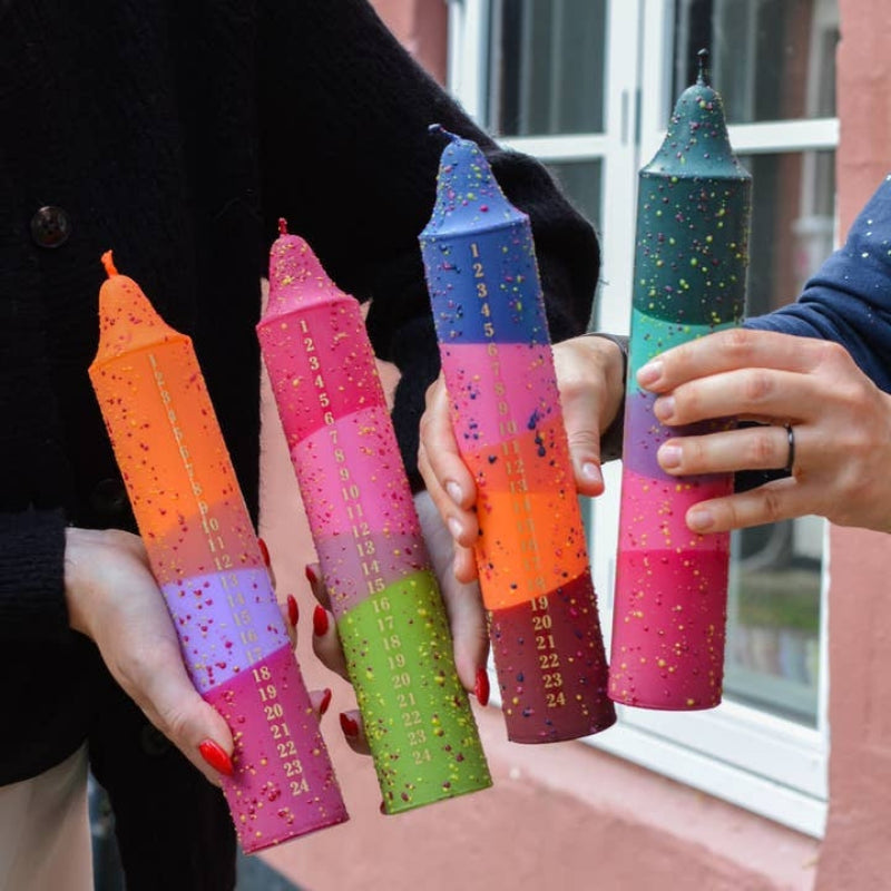 multi-color advent candles with numbers down the side to burn a section each day for countdown to christmas