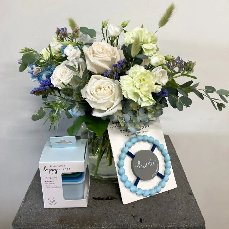Bouquet of flowers with a box and bracelet on a gray surface