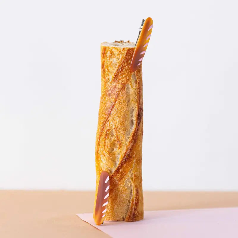 Baguette with a hair clip on a white background