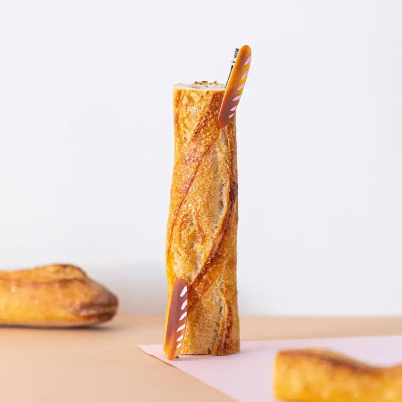 Baguette-shaped glass with a straw on a light background