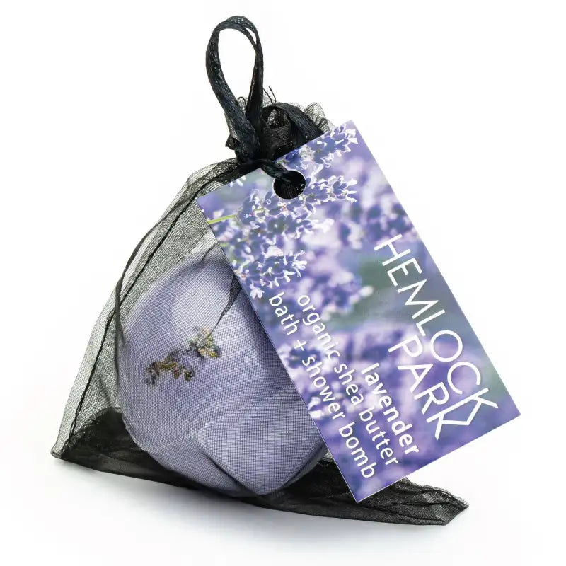Bath bomb in a black mesh bag with a Hemlock Park tag on a white background