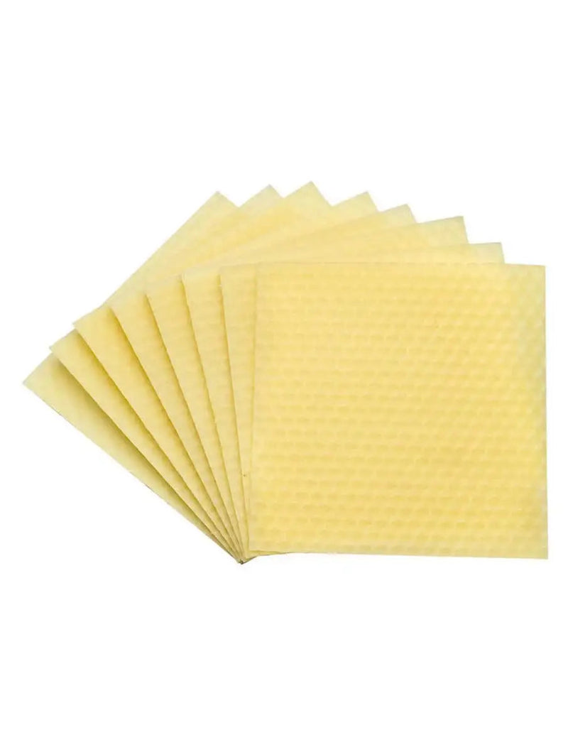 Stack of yellow honeycomb wax sheets on a white background