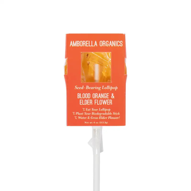Amborella Organics seed-bearing lollipop with orange packaging on a white background