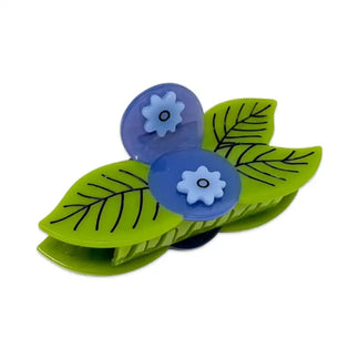 Hair clip with green leaves and blue flowers on a white background