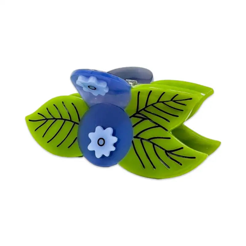 Two green leaf-shaped clips with blue centers featuring white flowers on a white background