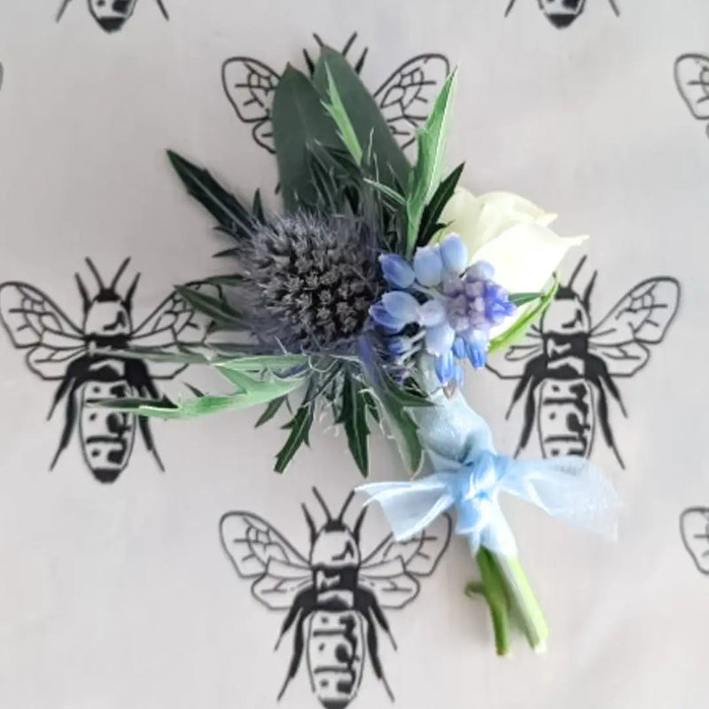 Floral arrangement with blue and white flowers on a background with bee illustrations