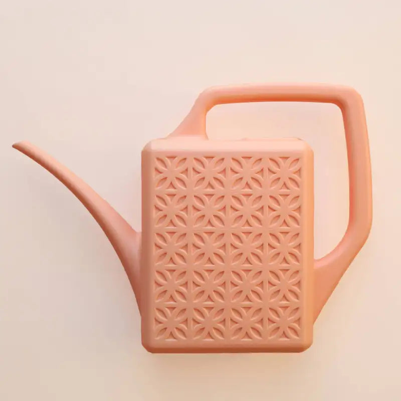 Pink watering can with geometric pattern on a beige background