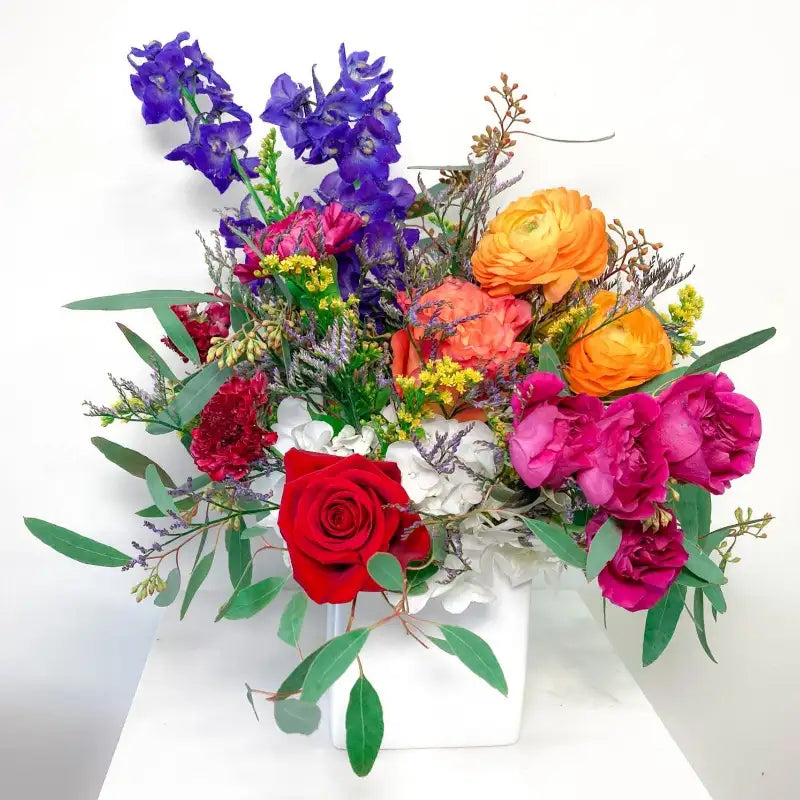 Colorful bouquet of flowers including roses and hydrangeas on a white background