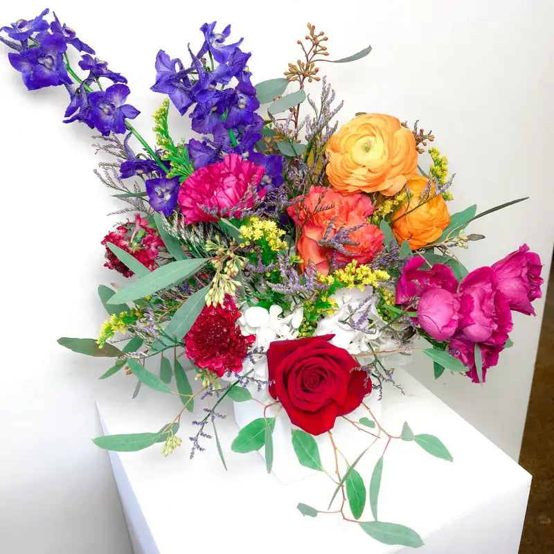 Colorful bouquet of flowers including red, pink, orange, and purple on a white background