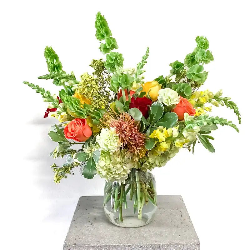 Colorful flower arrangement in a glass vase on a white background