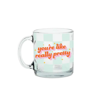 Clear glass mug with colorful text on a light green background