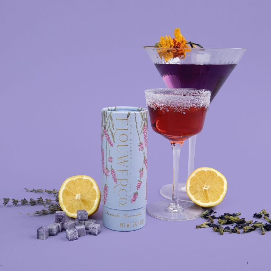 stylized photo of cocktail glasses with drinks and a tube of floral-infused cocktail cubes