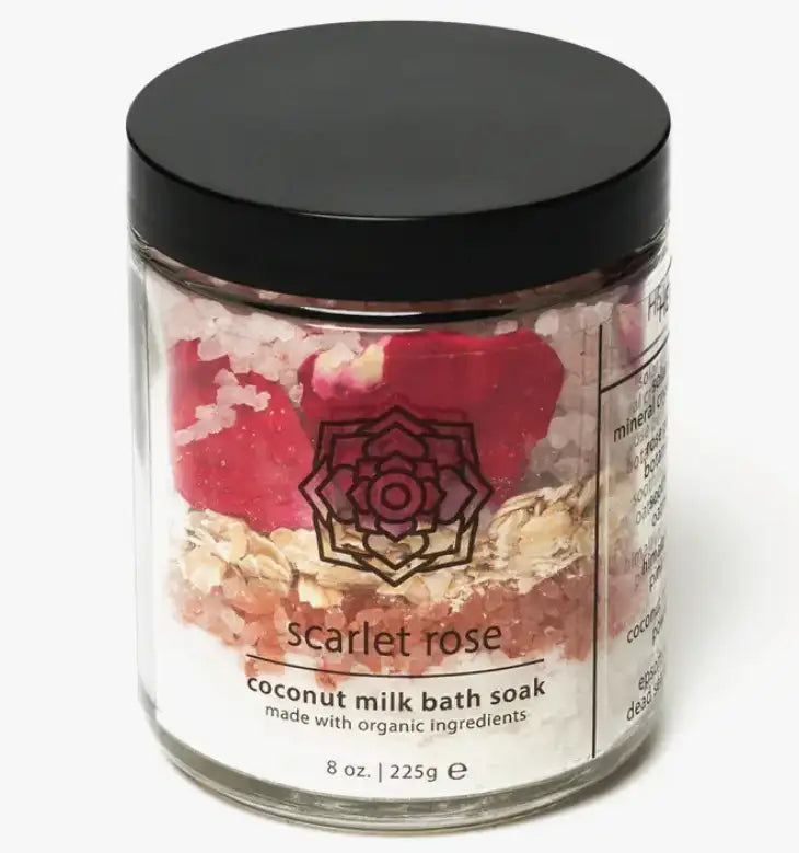 Jar of coconut milk bath soak with a black lid on a white background