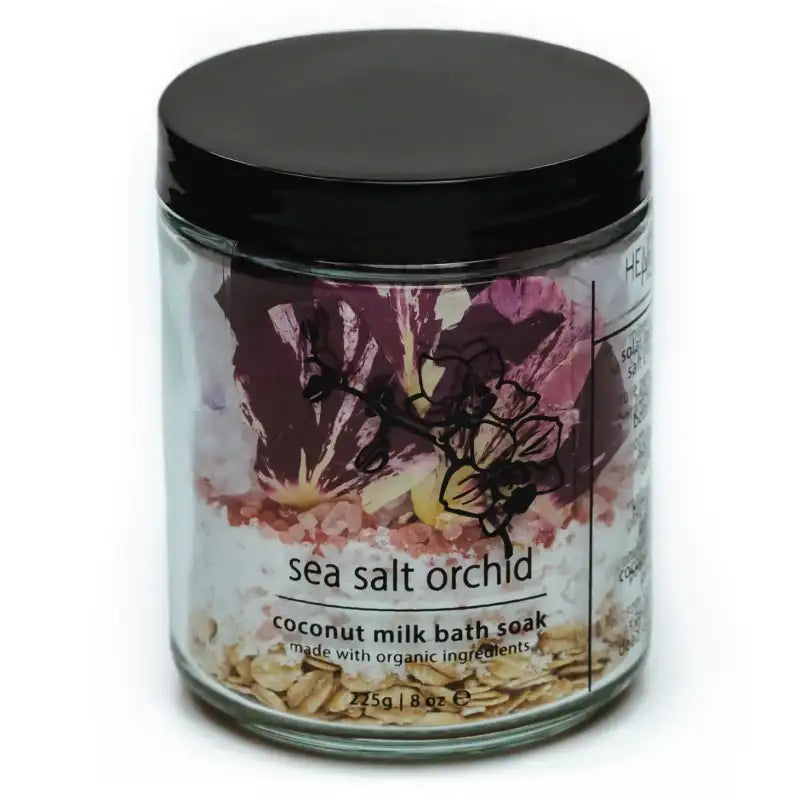 Jar of sea salt orchid coconut milk bath soak with floral label on a white background