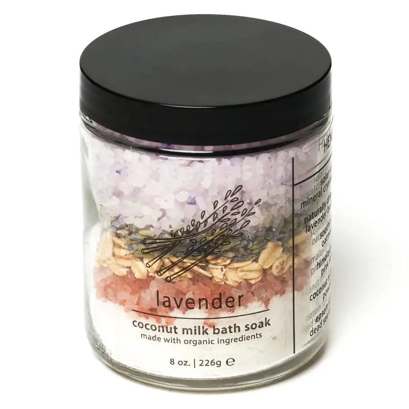Jar of lavender coconut milk bath soak with a black lid on a white background
