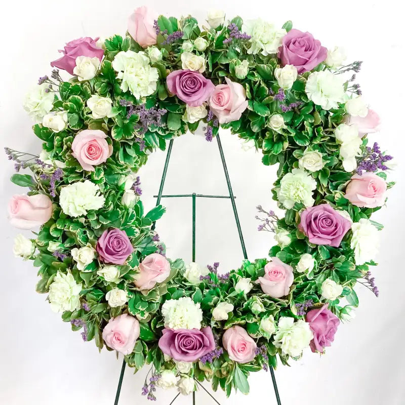 Floral wreath with pink, white, and purple flowers on a white background