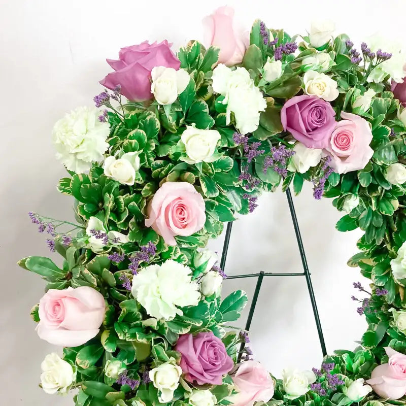 Floral wreath with pink, white, and purple flowers on a white background