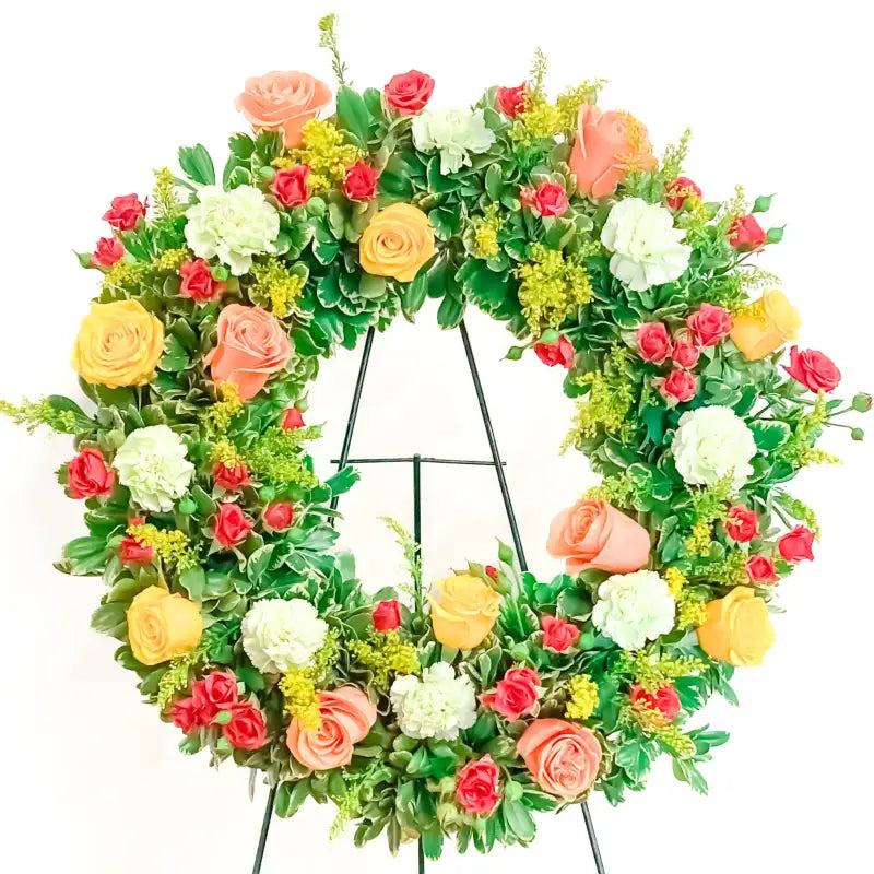 Colorful floral wreath with greenery on a white background
