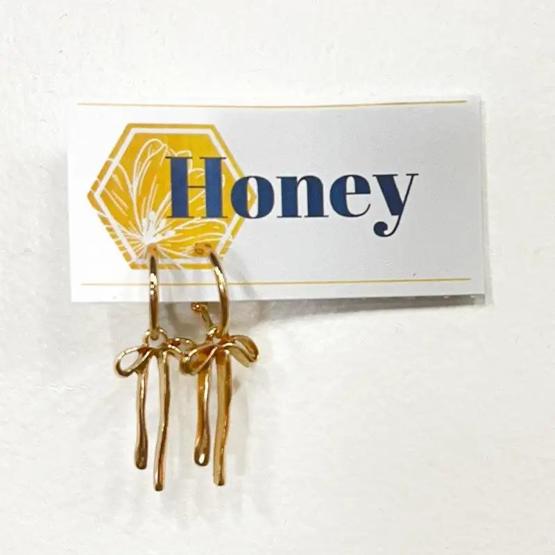 Gold earrings on a 'Honey' branded card against a white background