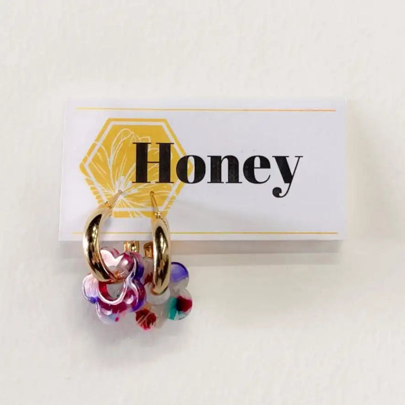 Gold hoop earrings with colorful beads on a 'Honey' branded card.