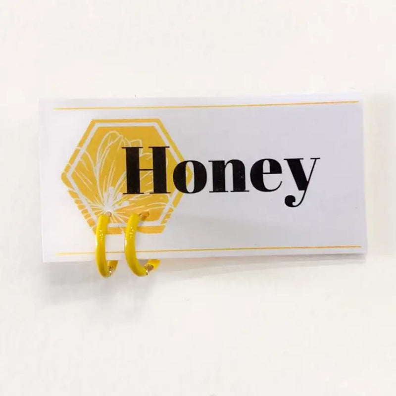 Decorative sign with 'Honey' text and a honeycomb design on a white background
