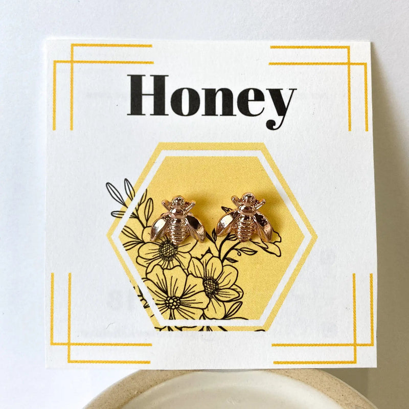 Earring card with bee and flower design on a white background