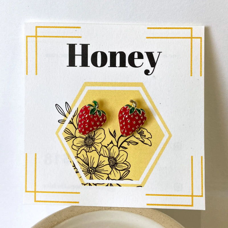 Card with strawberry earrings and 'Honey' text on a white background