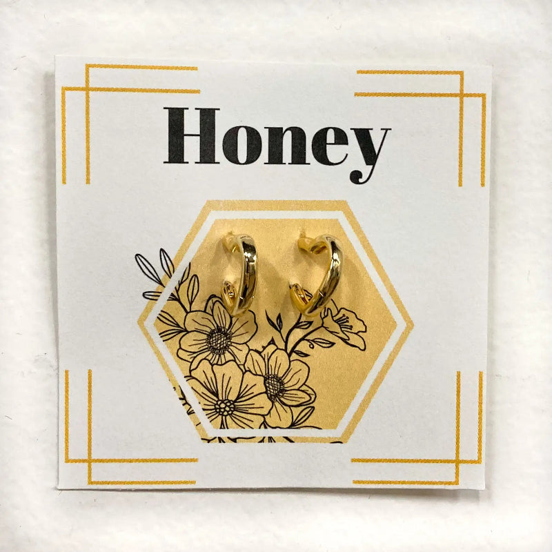 Gold hoop earrings on a 'Honey' branded card with floral design