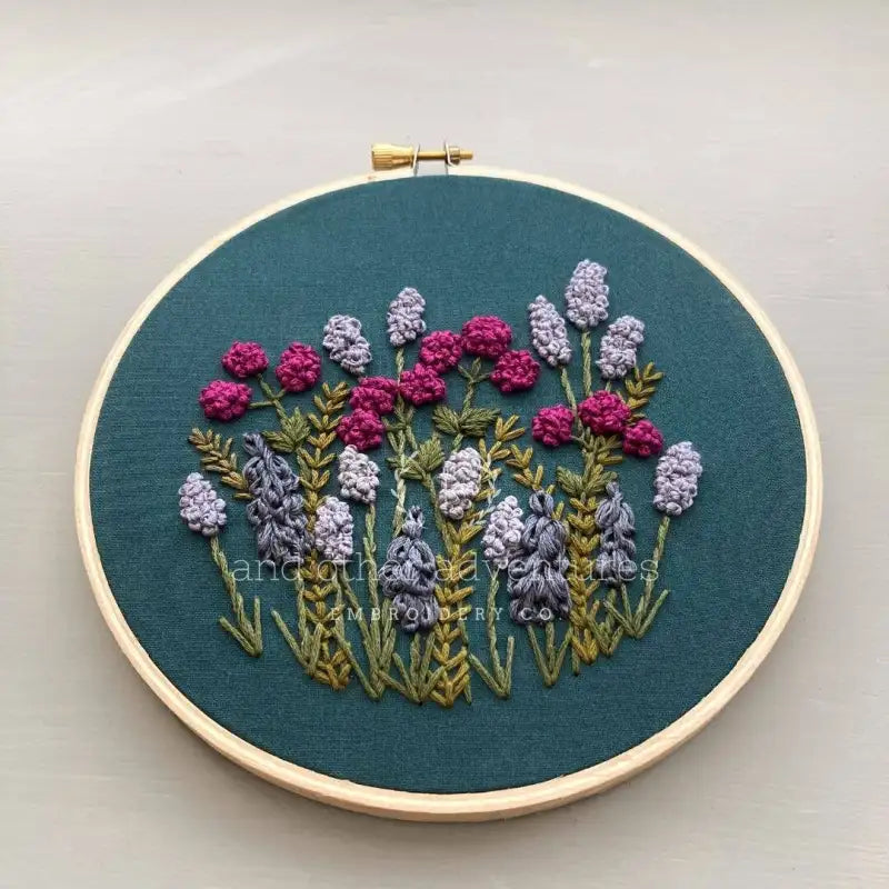 Embroidery hoop with floral design on a teal fabric background