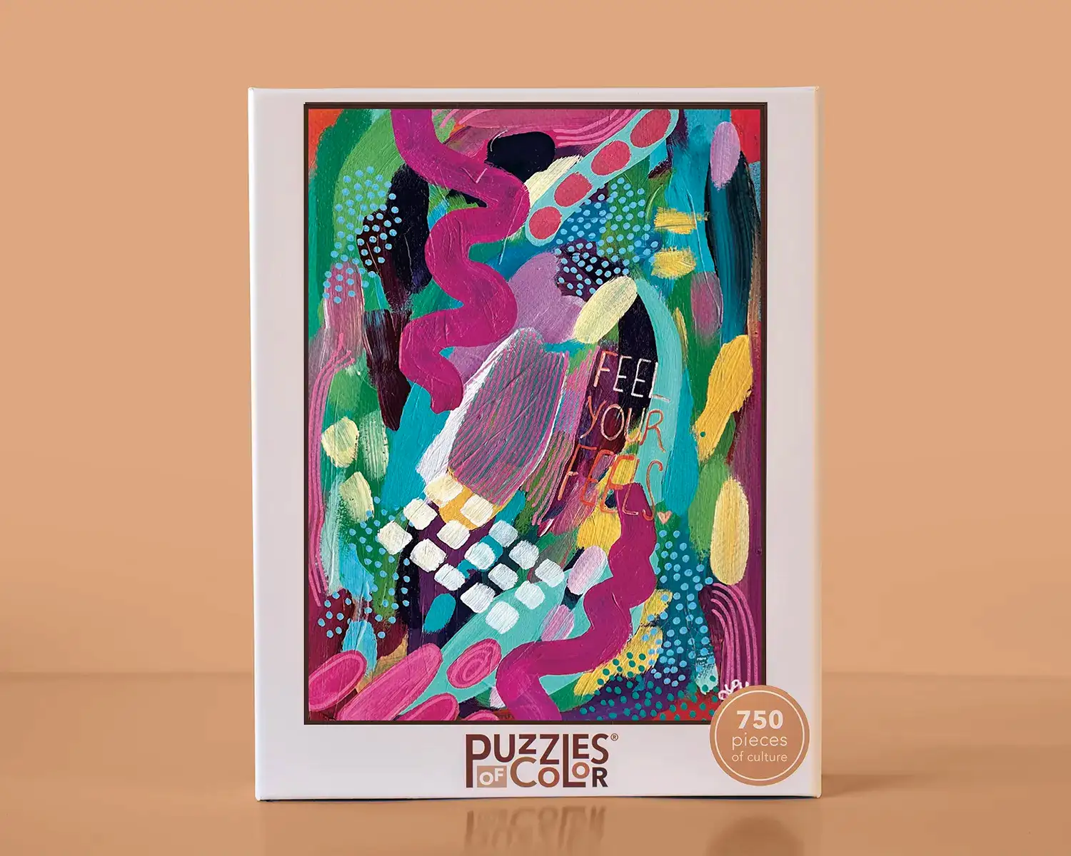 Colorful puzzle packaging with abstract design and 'Puzzles of Color' branding on a beige background