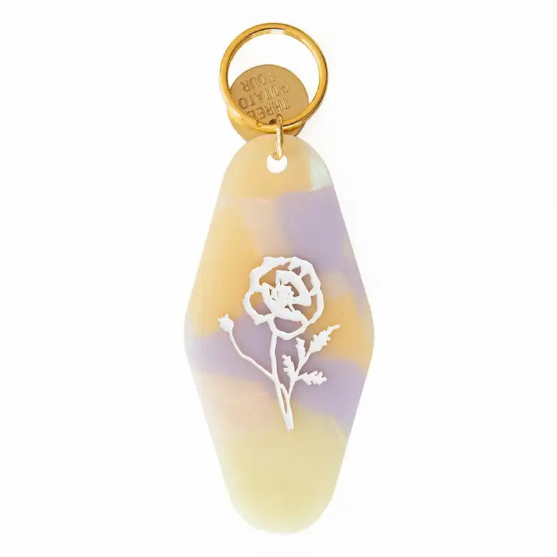 Keychain with a rose design on a yellow and purple background