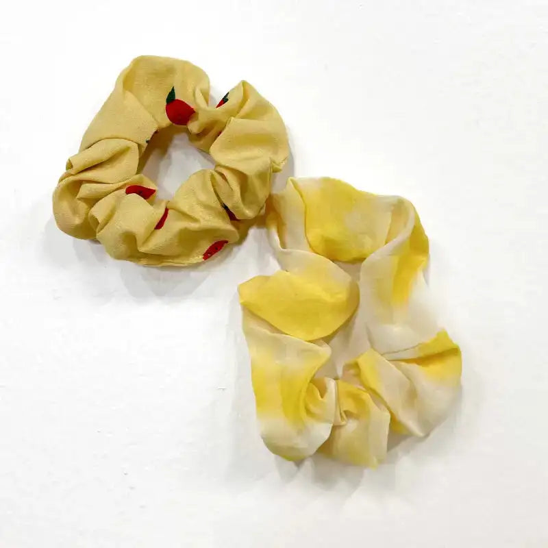 Yellow scrunchie with red accents on a white background