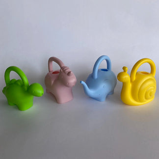 Four colorful animal shaped watering cans (green, pink, blue, yellow) on a white background