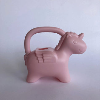 Pink unicorn-shaped watering can on a light gray background