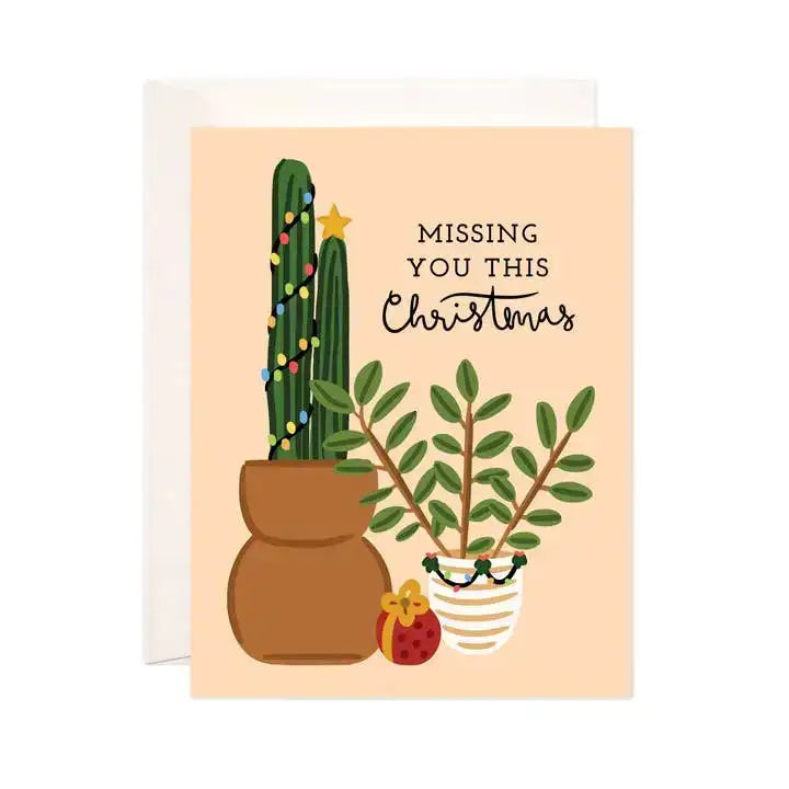 Greeting card with potted plants and text 'Missing You This Christmas' on a peach background