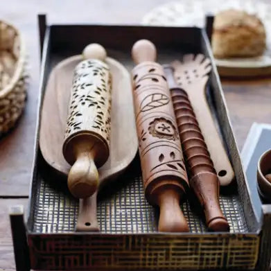 Set of wooden rolling pins with embossed designs in a decorative box.