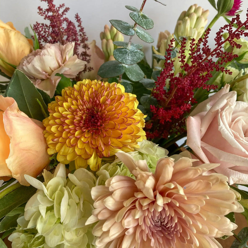 Bouquet of colorful flowers including orange, pink, and green.