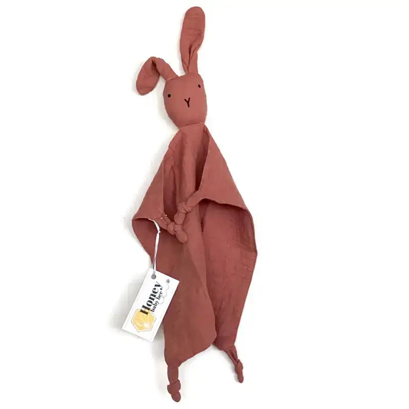 Brown rabbit-shaped fabric toy with a tag on a white background