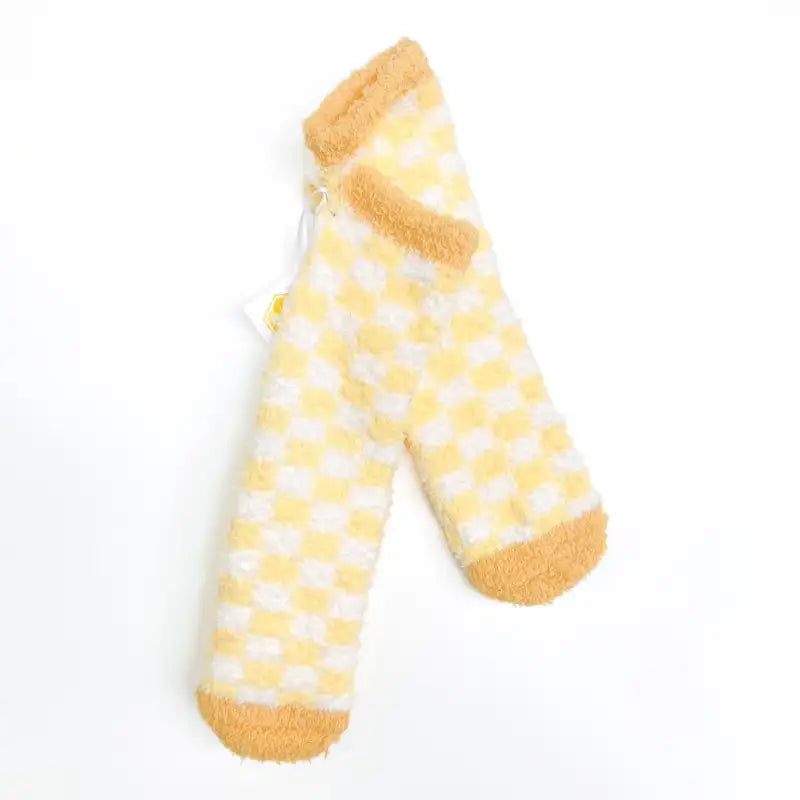 Pair of yellow and white checkered socks with yellow cuffs and toes on a white background
