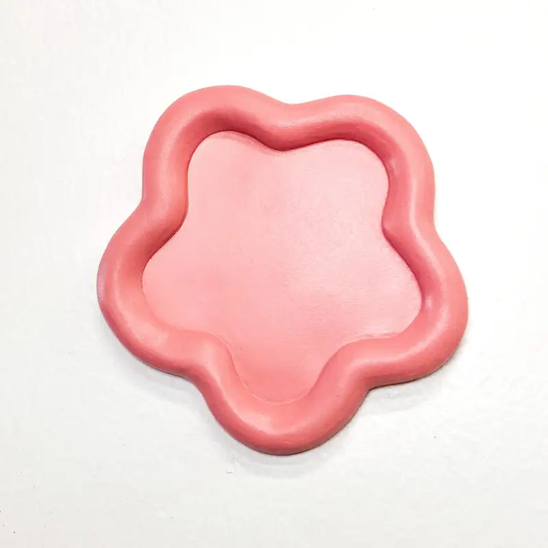 Pink, flower-shaped object on a white background