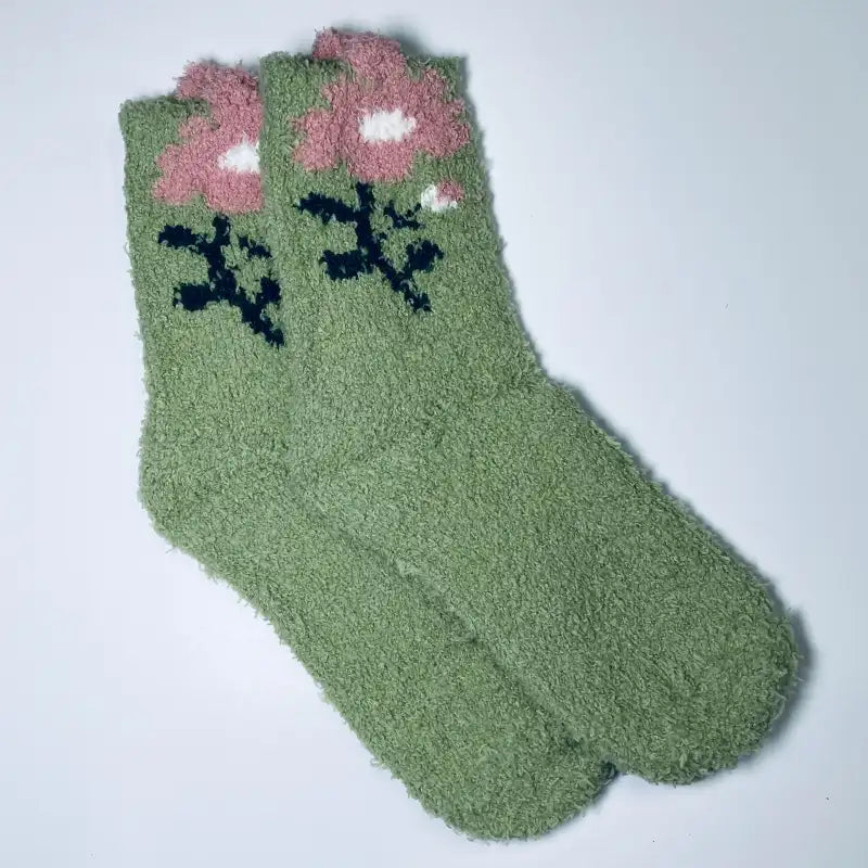 Green socks with pink floral design on a white background