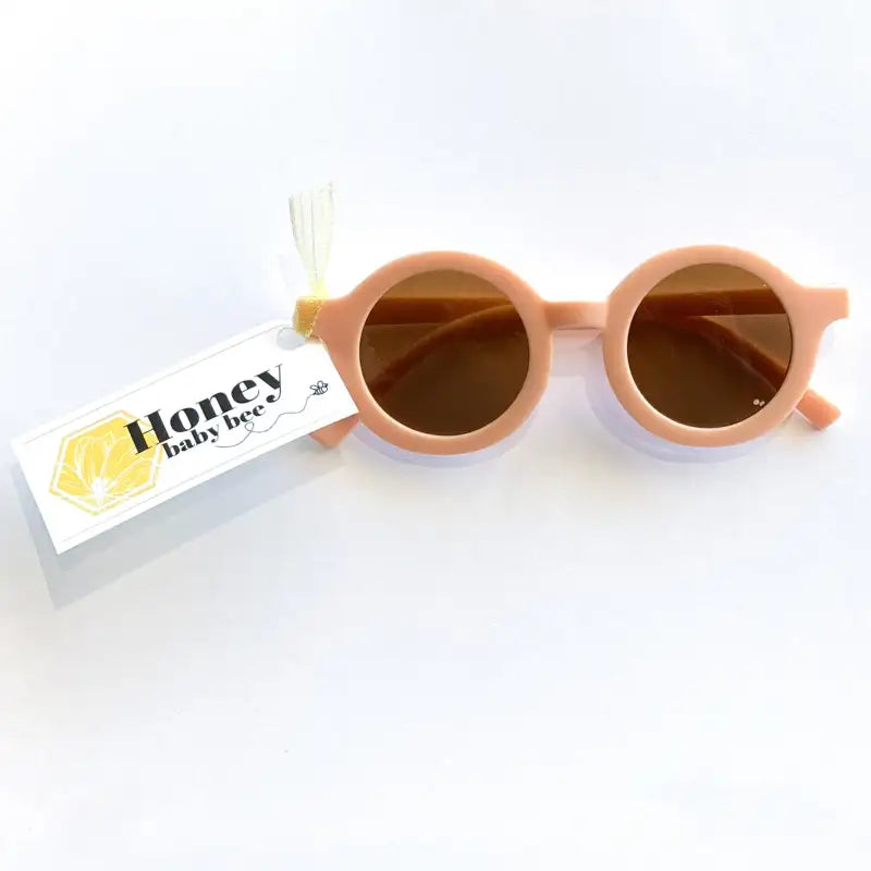 Children's sunglasses with a 'Honey baby bee' tag on a white background