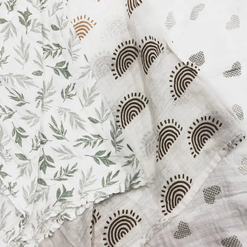 Fabric with leaf pattern, rainbow patterns, and heart shapes on a white background