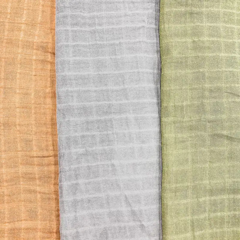 Three fabric swatches in brown, gray, and green on a striped background