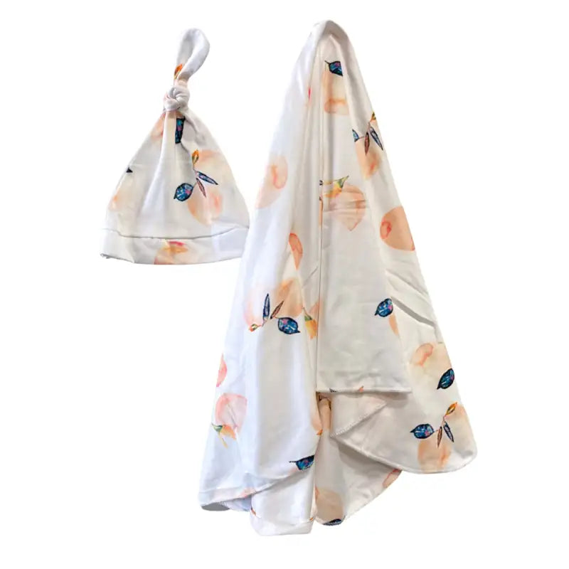 Baby hat and blanket set with floral pattern on a white background